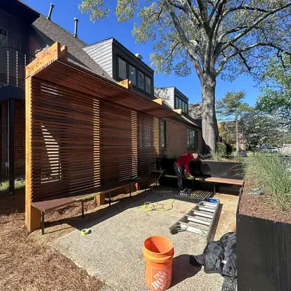 A slatted wood privacy screen with a built in bench