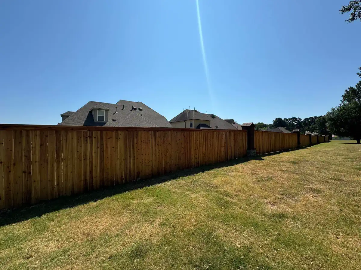 A long stained cedar privacy fence along a yard