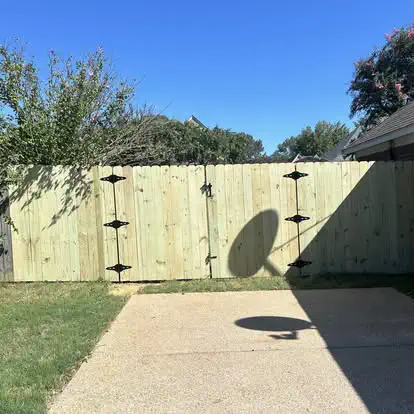 A new wood fence with black gate hinges