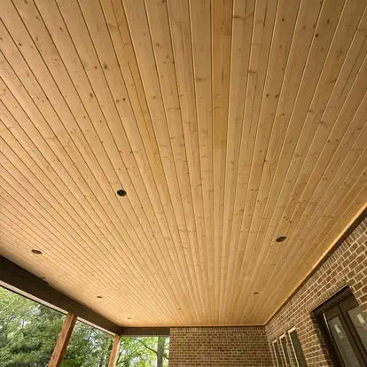 A tongue and groove porch ceiling with recessed lights