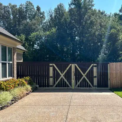 A dark stained privacy fence with a double drive gate
